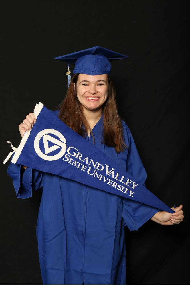 graduate holding gvsu flag